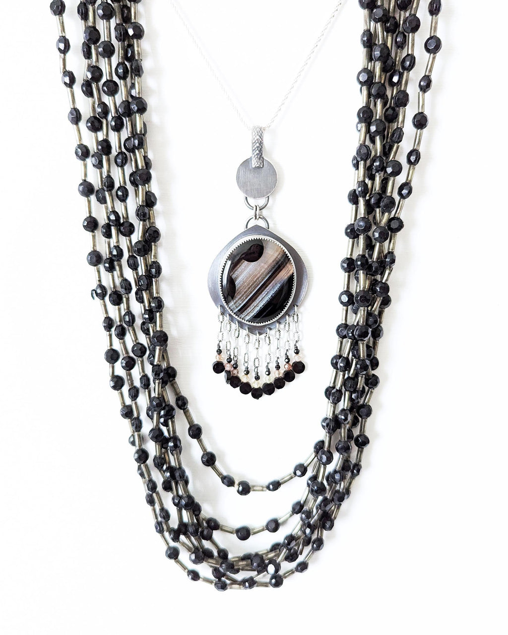 Round black banded agate pendant with leaf-shaped oxidized silver frame