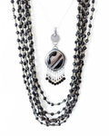 Round black banded agate pendant with leaf-shaped oxidized silver frame