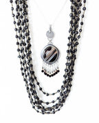 Round black banded agate pendant with leaf-shaped oxidized silver frame