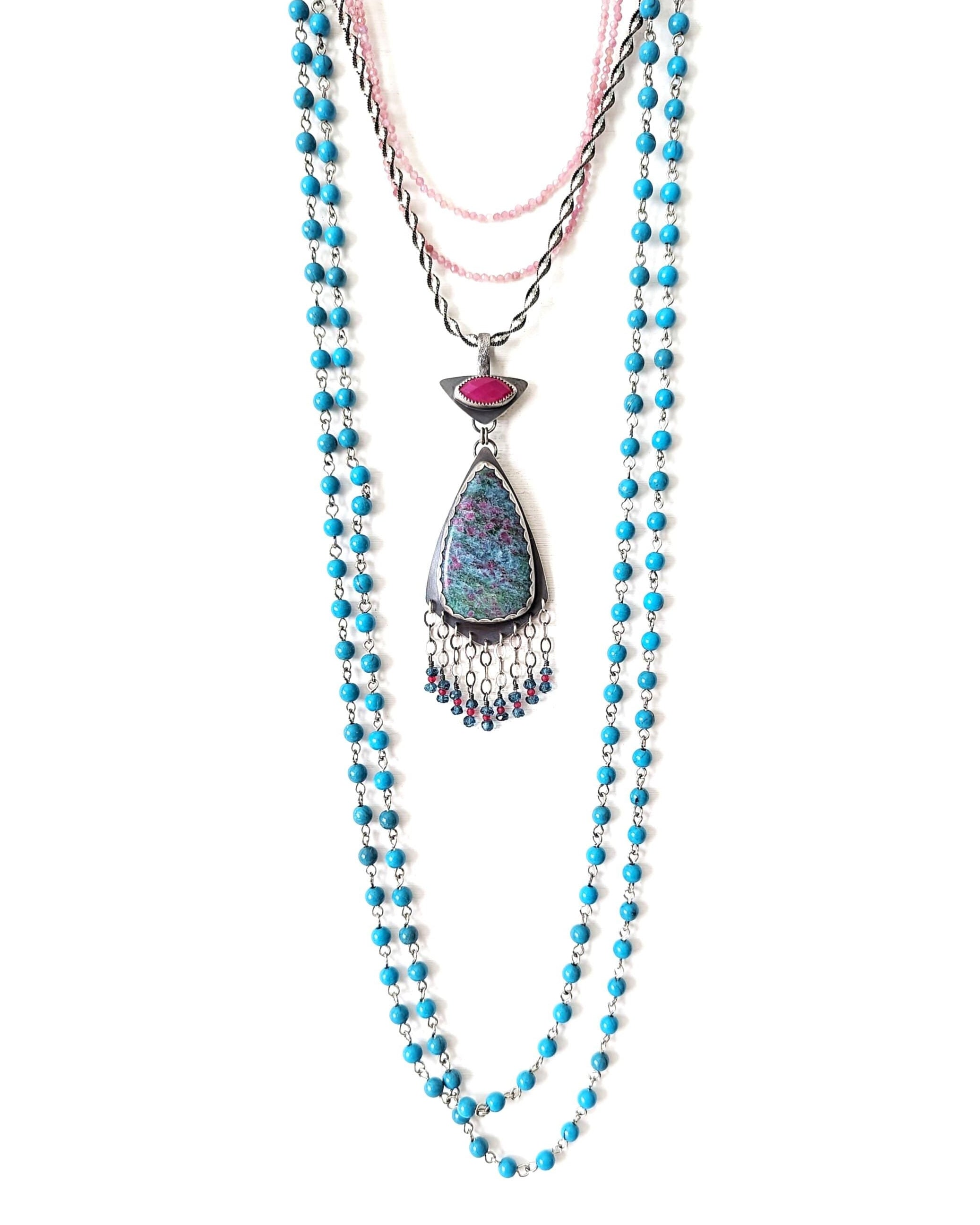 Colorful ruby in kyanite pendant shown on chain with other layering necklaces for styling