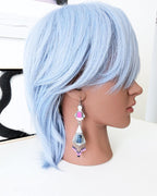 Luxury artisan earrings featuring pietersite and calcite on mannequin for scale