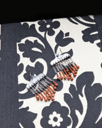 Orange goldstone earrings with hammered oxidized sterling silver and bead drops on fabric background

