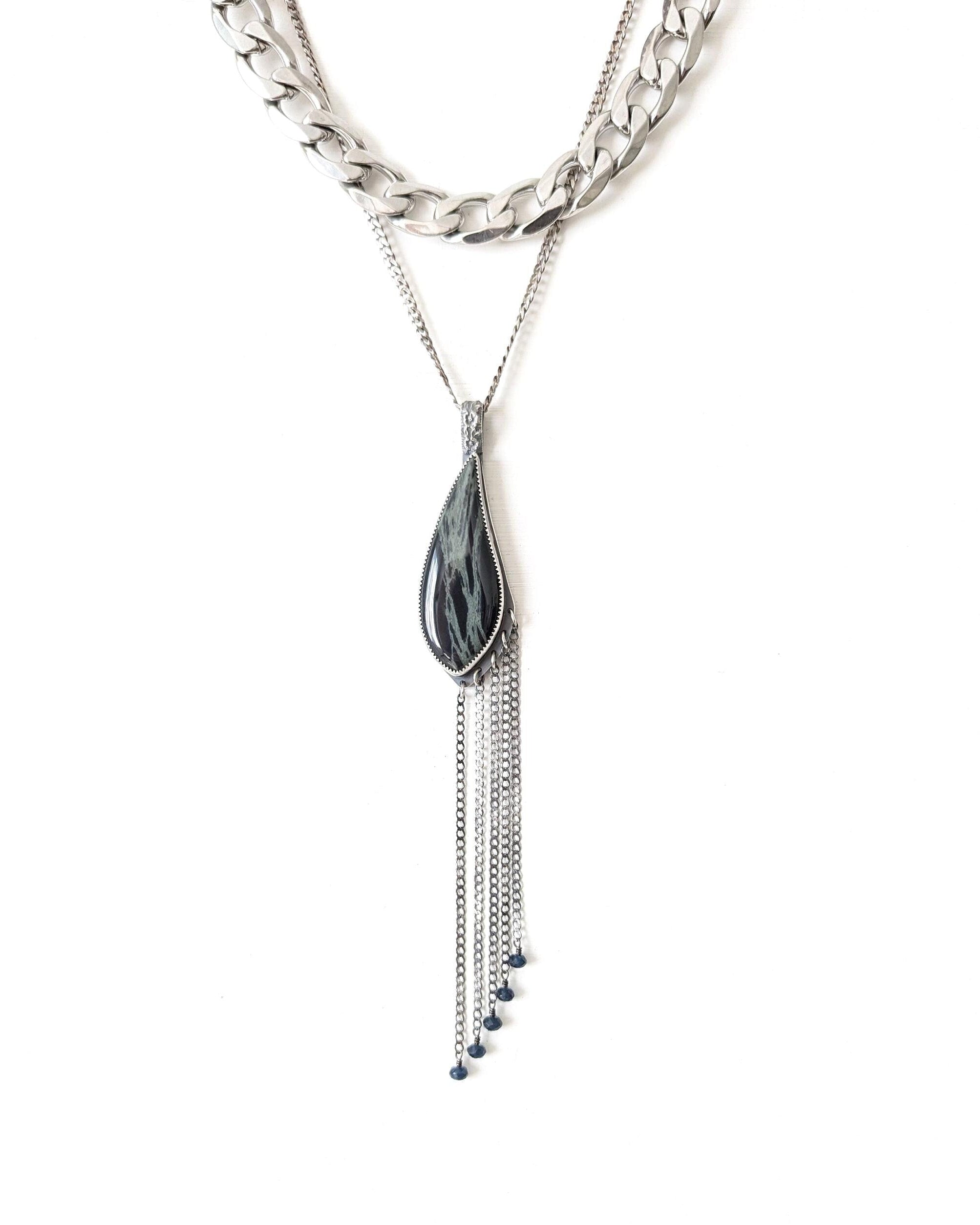 Necklace with a leaf-shaped pendant and chain on a white background