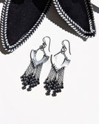 Black beaded earrings on a white background with hammered sterling silver horseshoe elements