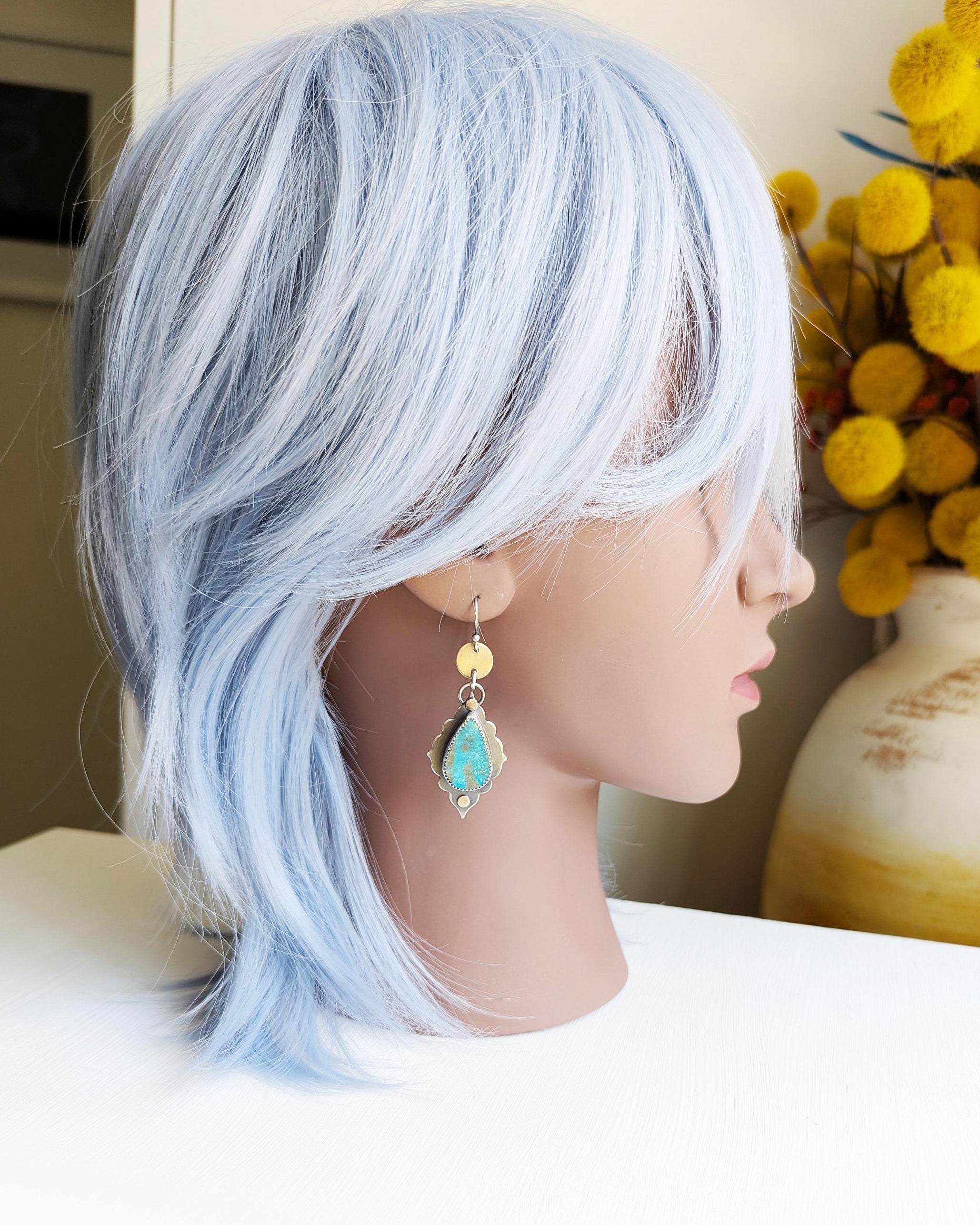 Modern boho statement earrings with turquoise and grey gemstone drops on a mannequin for scale