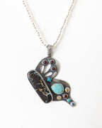 Butterfly pendant worn on a silver chain to show how the pendant hangs.
