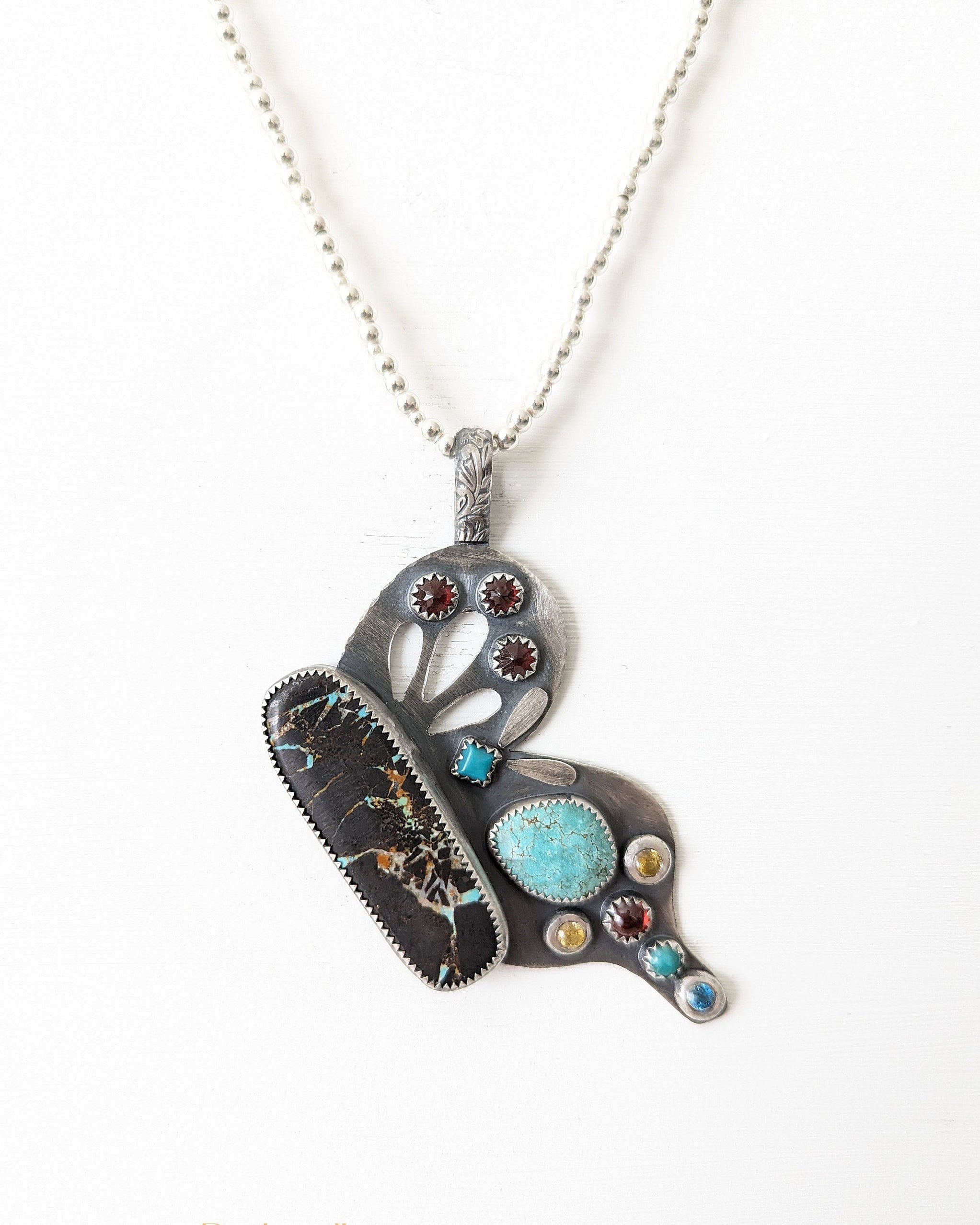Butterfly pendant worn on a silver chain to show how the pendant hangs.
