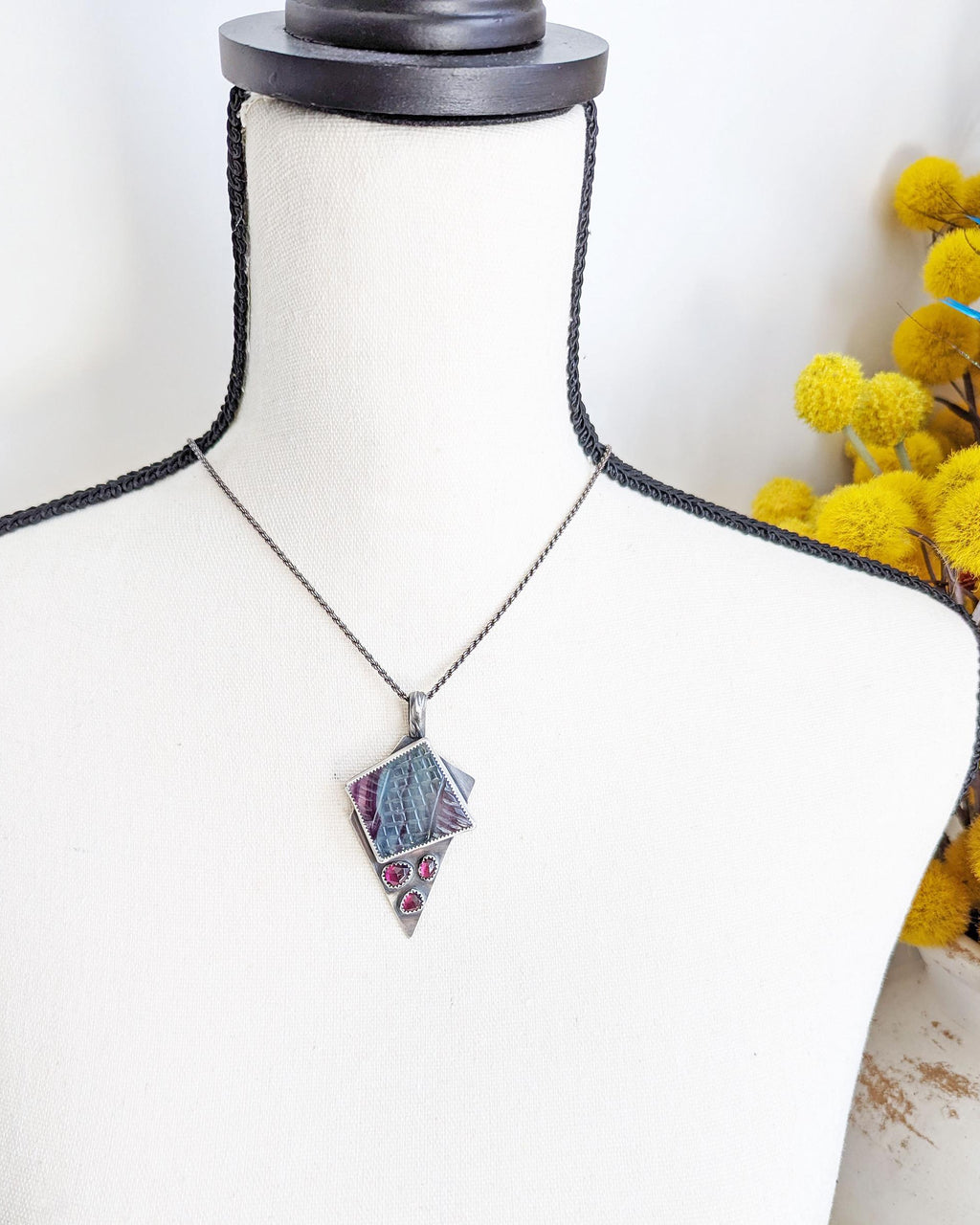 Artisan multi stone rainbow fluorite and garnet pendant shown on bust for scale
