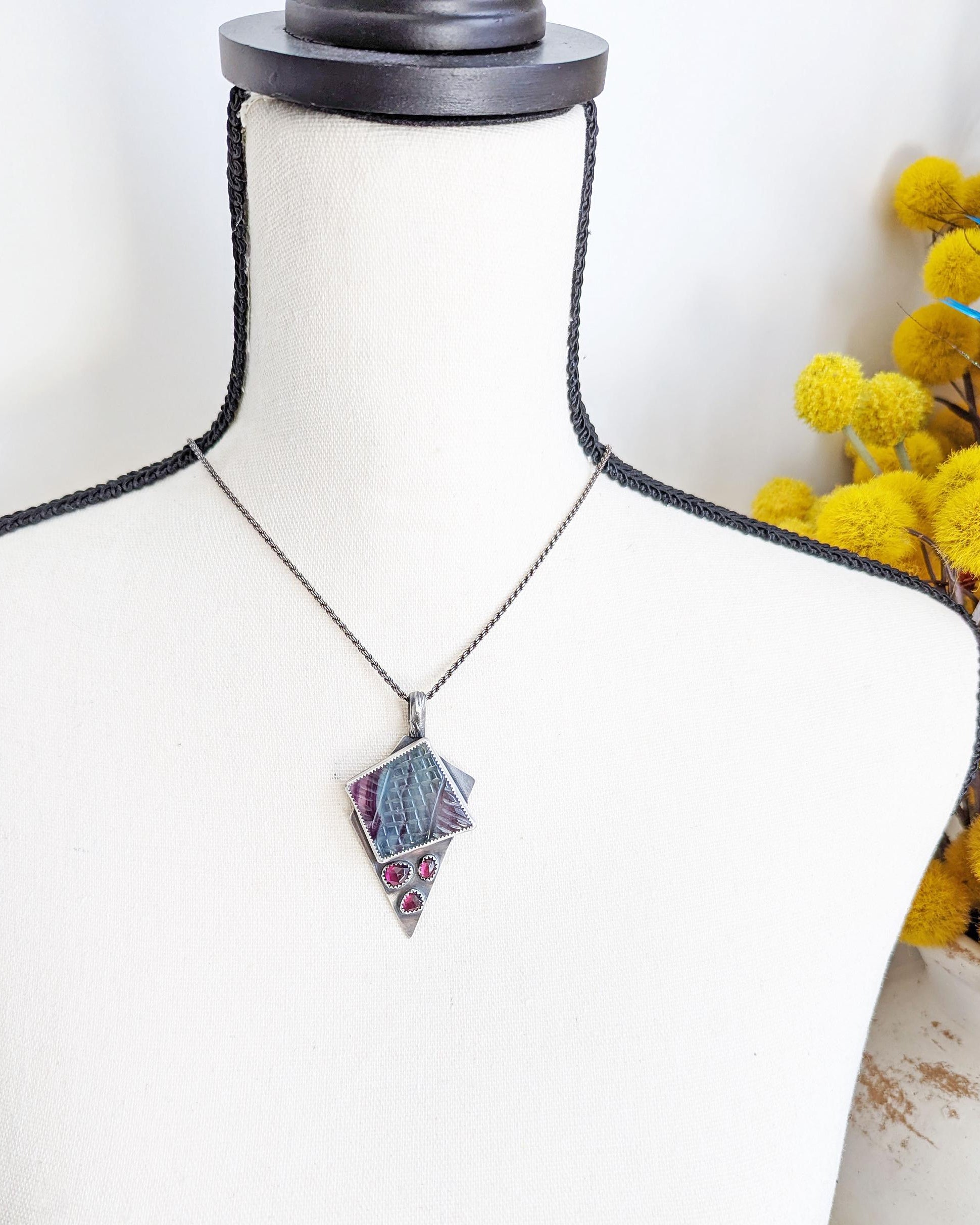 Artisan multi stone rainbow fluorite and garnet pendant shown on bust for scale