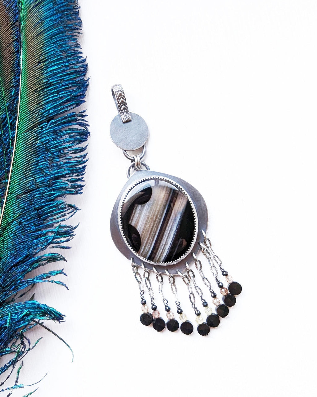 Round black banded agate pendant with leaf-shaped oxidized silver frame and bead fringe