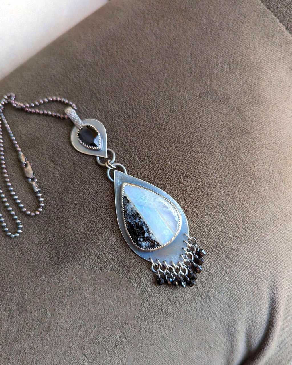 Black spinel beaded fringe beneath luminous white moonstone on chain (not included)