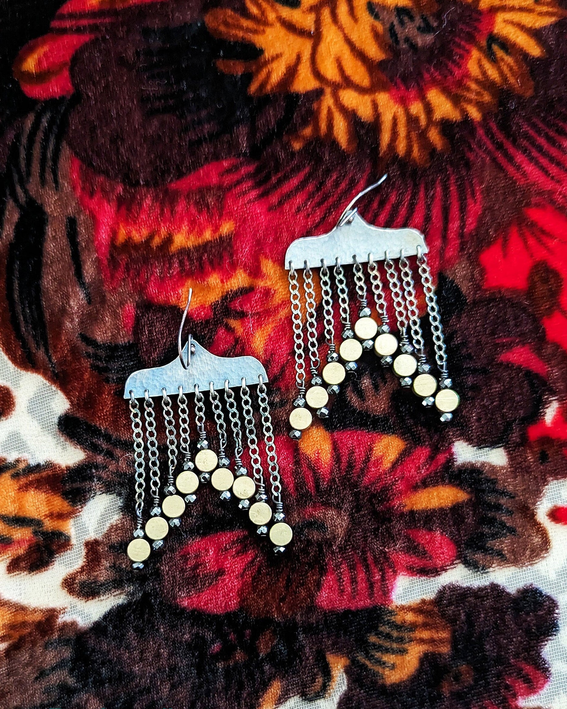 Curvy artisan silver earrings with cascading brass coin detail