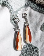 Dramatic chain fringe earrings with warm autumn gemstone tones in natural sunlight
