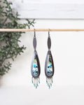Pair of earrings with a decorative design on a white background