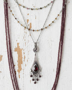 Deep red garnet bead fringe beneath romantic silver setting on chain with layering necklaces (not included)