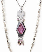 Geometric oxidized sterling silver pendant with raw ruby centerpiece in bright light