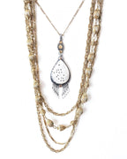 Romantic coastal pendant featuring carved mother of pearl and delicate beaded accents shown with layering necklace for styling