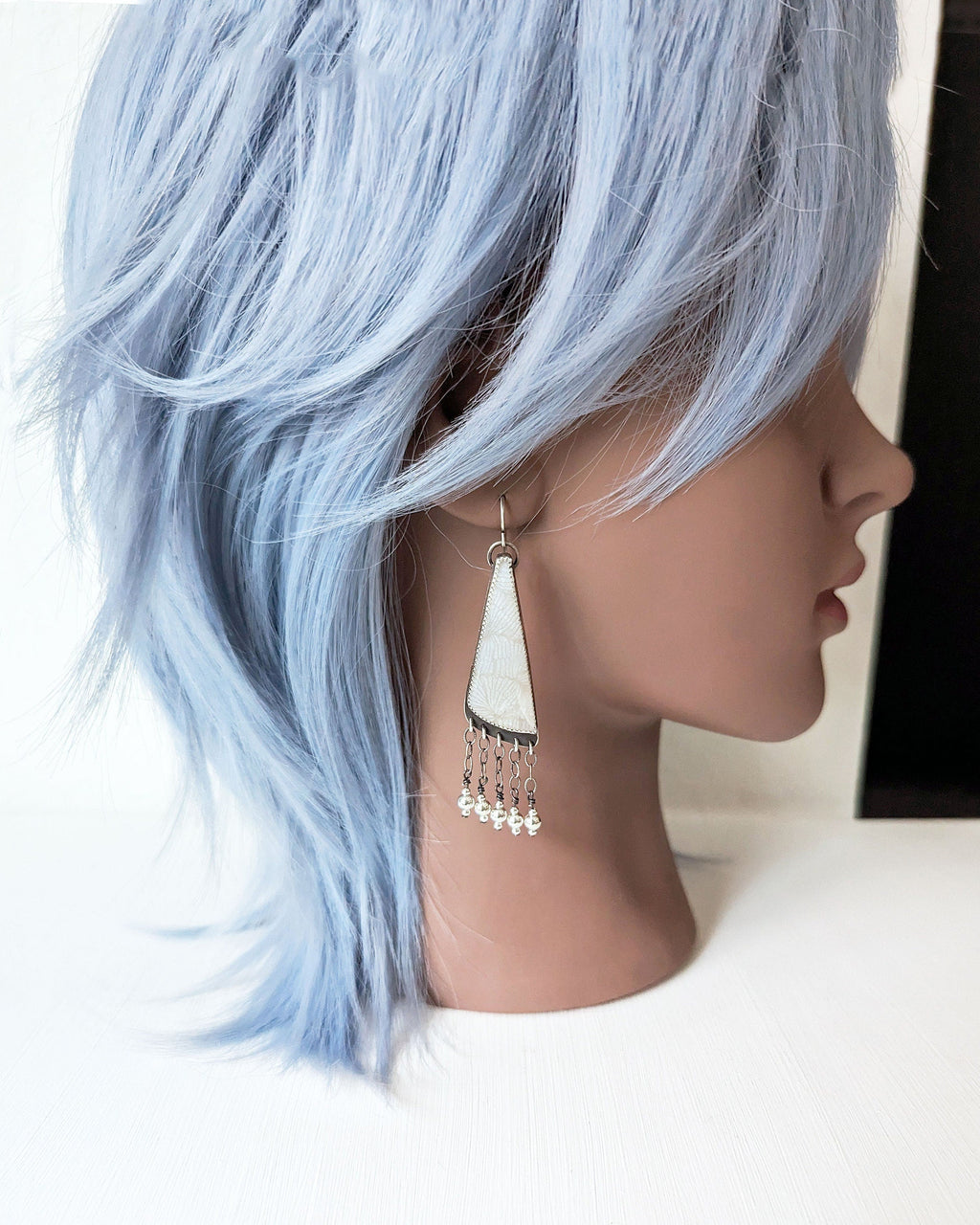 Nature-inspired white gemstone statement earrings on mannequin for scale