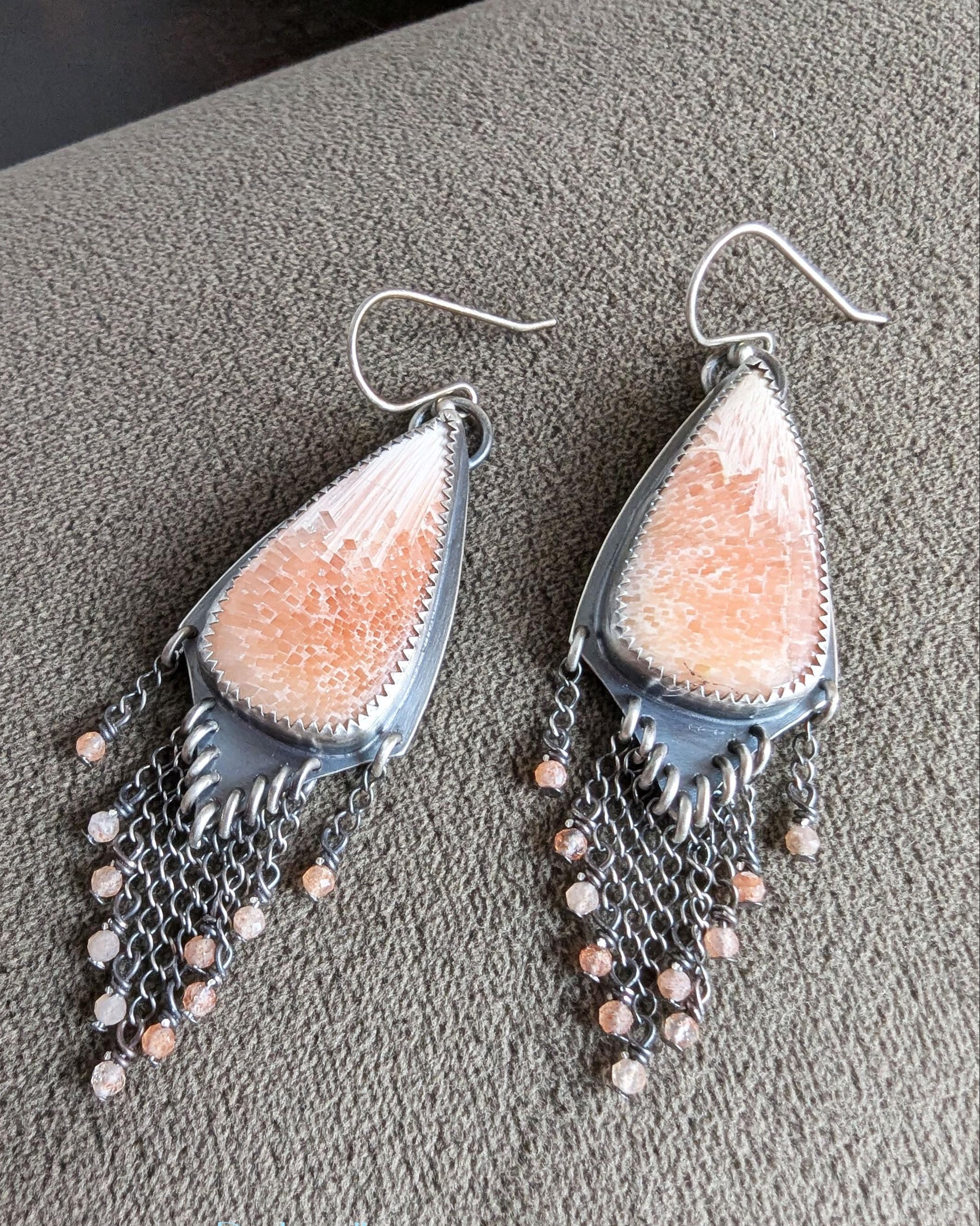 Close up of long shield statement earrings with peach scolecite mosaic stones 