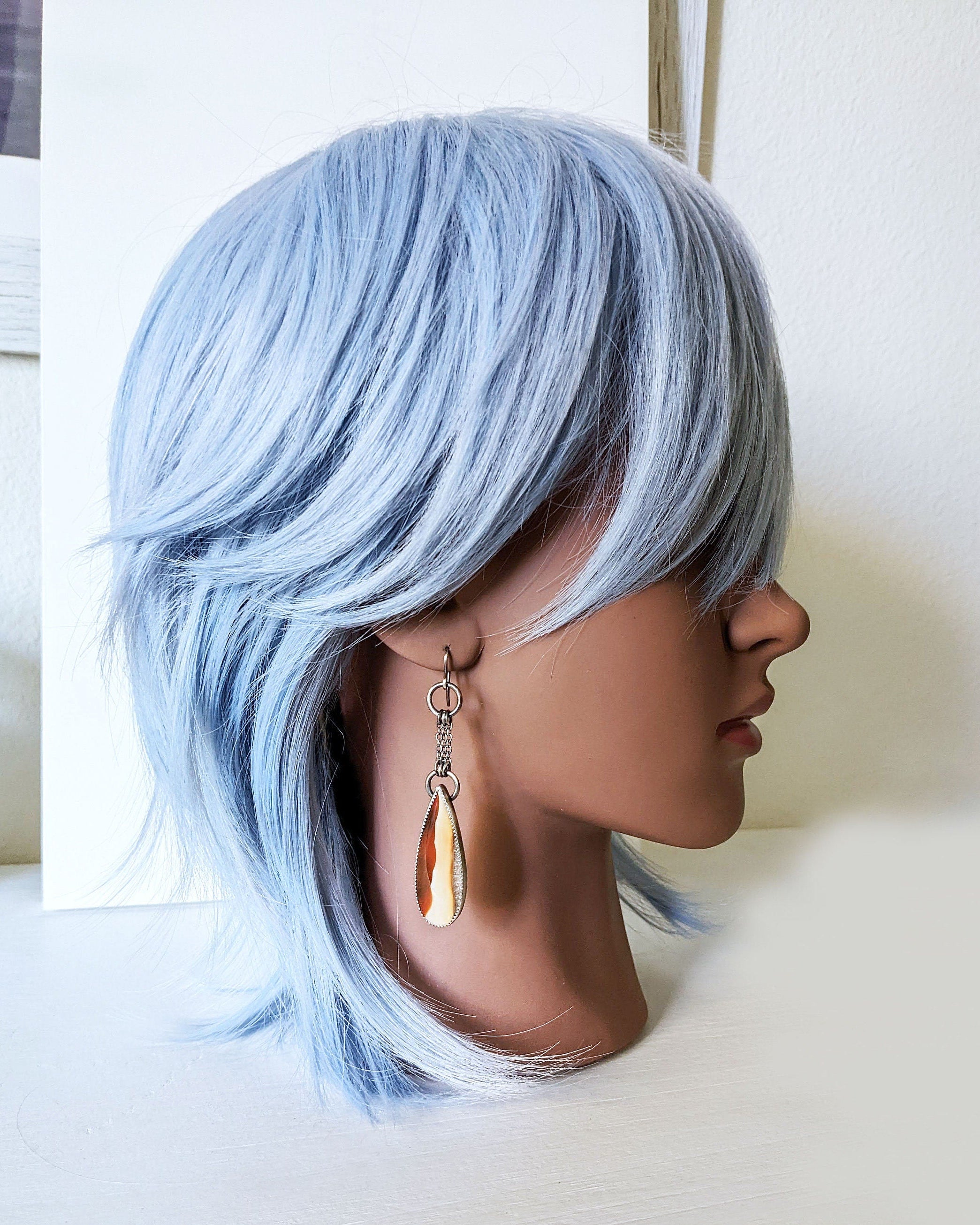 Collector gemstone earrings with vertically striped agate centerpiece on mannequin for scale
