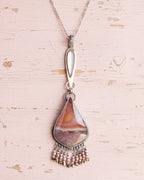 Feminine artisan necklace with AB crystal and vintage glass detail shown on chain with layer necklace (not included)