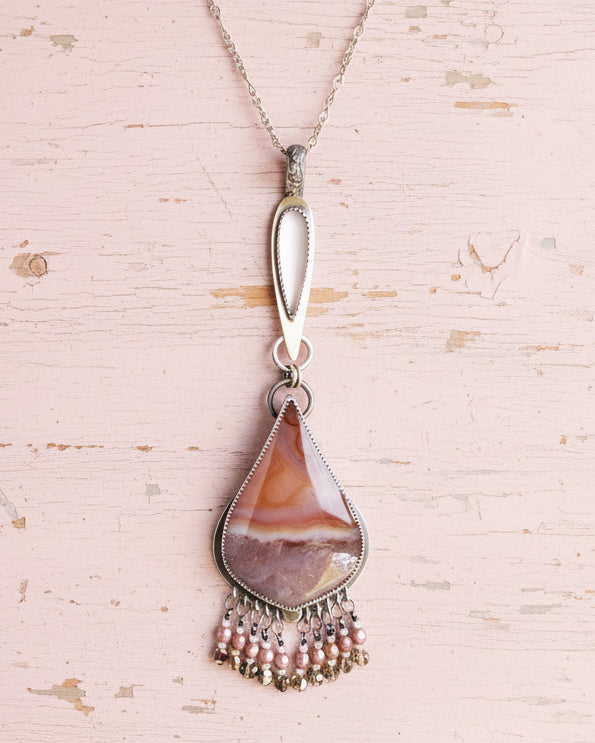 Feminine artisan necklace with AB crystal and vintage glass detail shown on chain with layer necklace (not included)