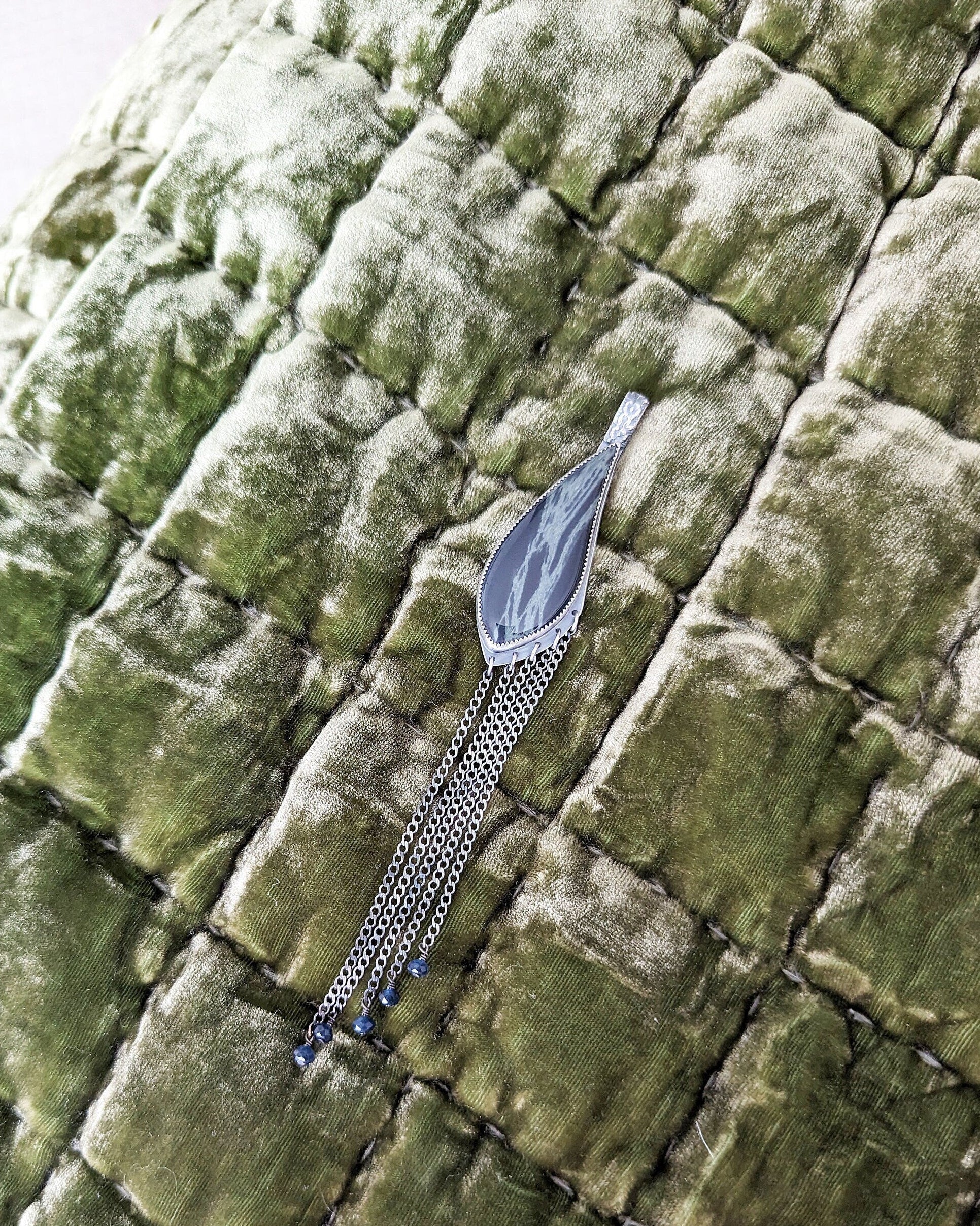 Decorative hairpin on a textured green fabric background 
