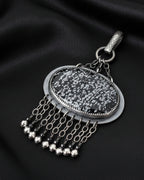Close-up of oval snowflake obsidian showing natural black and white crystal pattern

