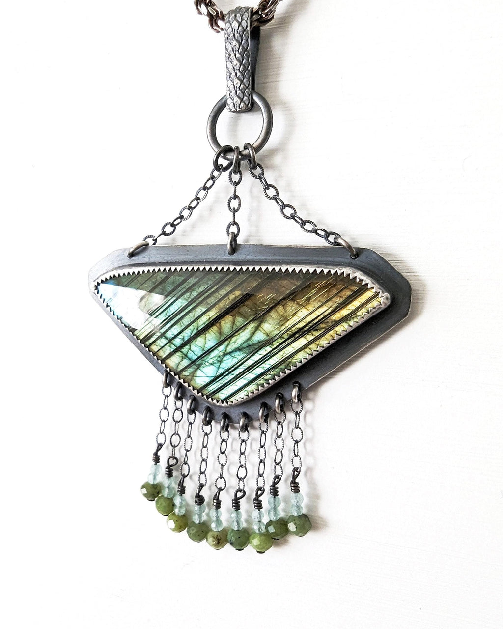 Angled close-up of rose-cut labradorite showing blue, gold, and green iridescent flash
