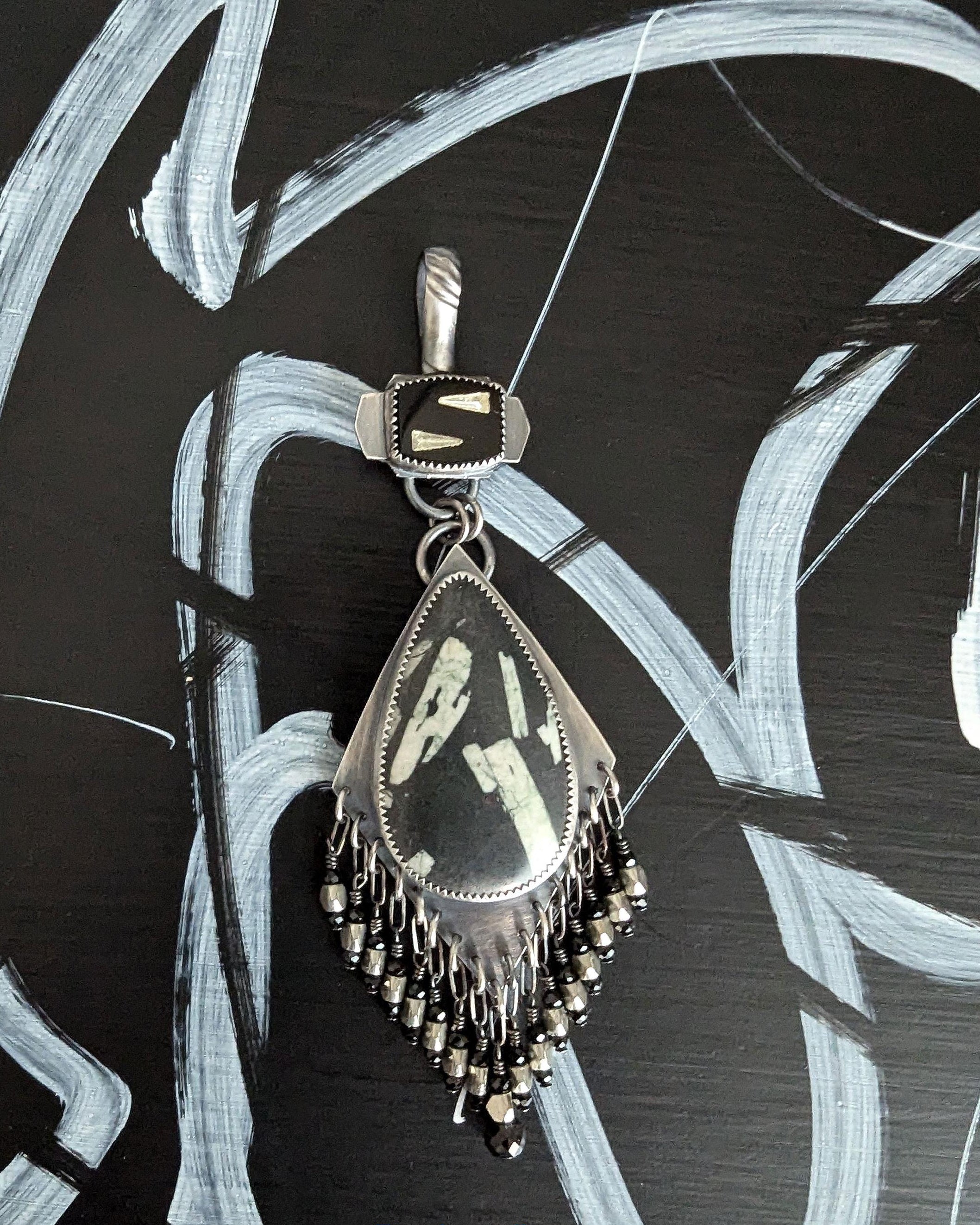 Close up of pear shaped Chinese writing stone pendant with spinel bead fringe