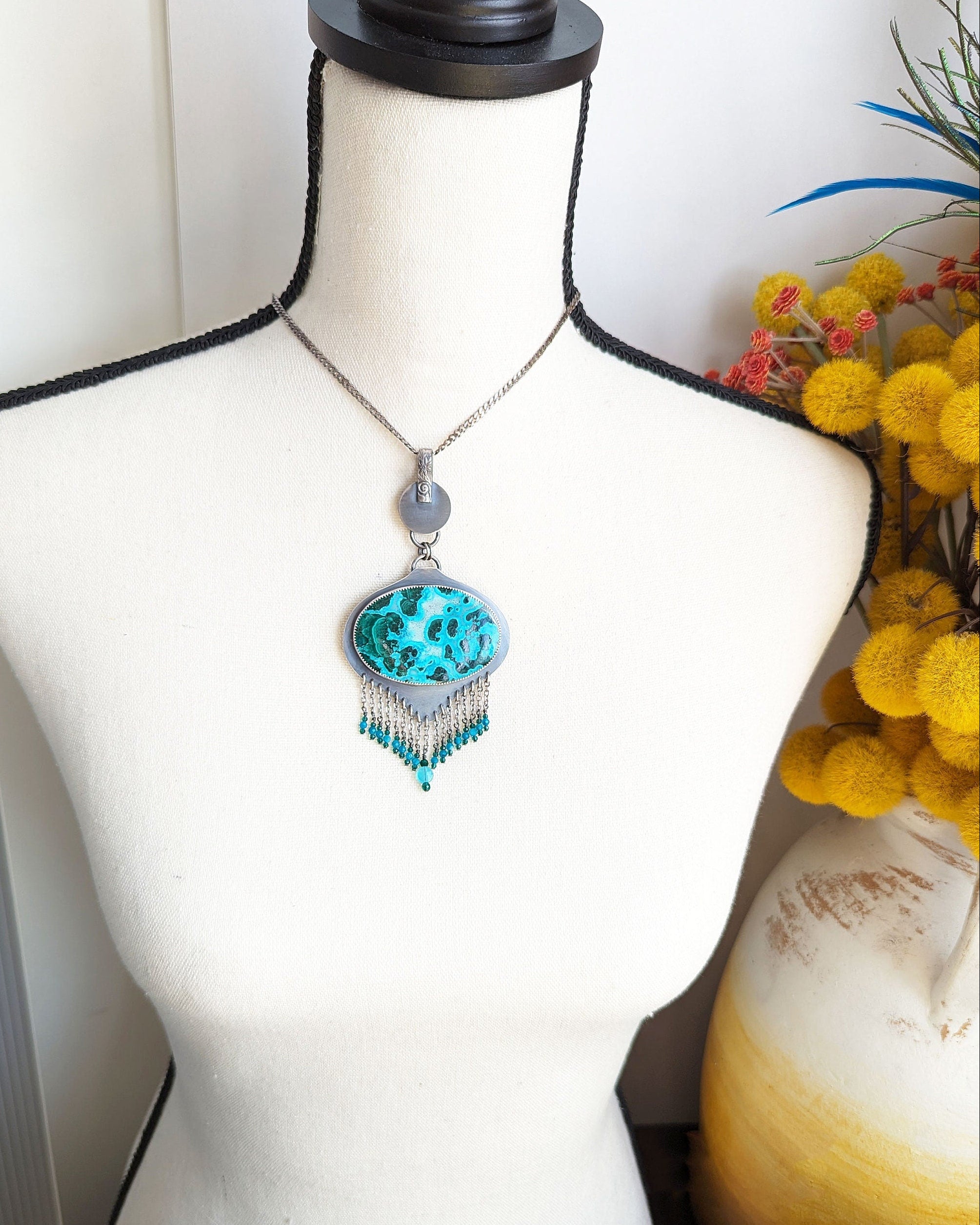 Ocean-inspired blue and green gemstone statement pendant shown on bust for scale