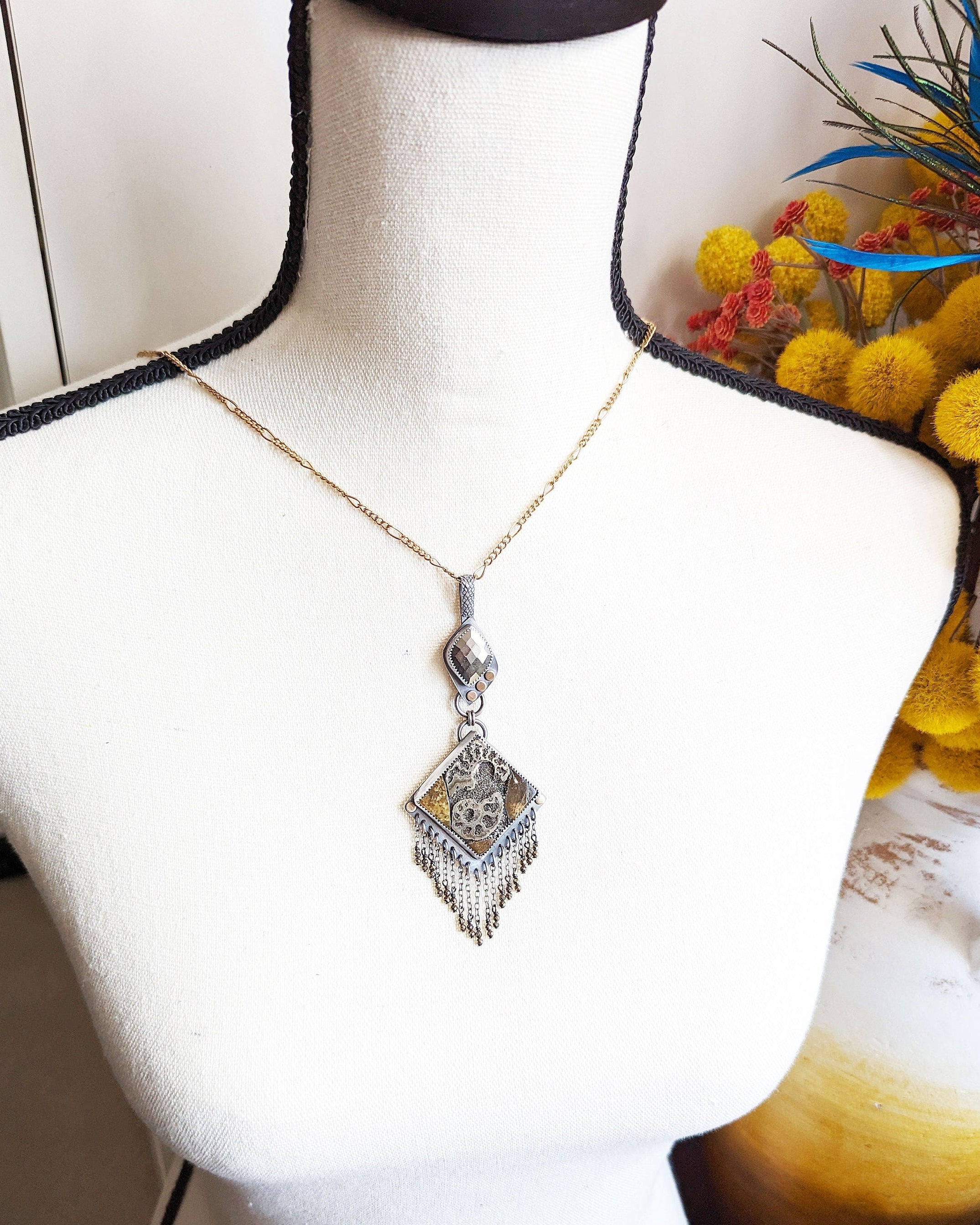 Handcrafted ammonite mosaic necklace with mixed metals and pyrite shown on bust for scale