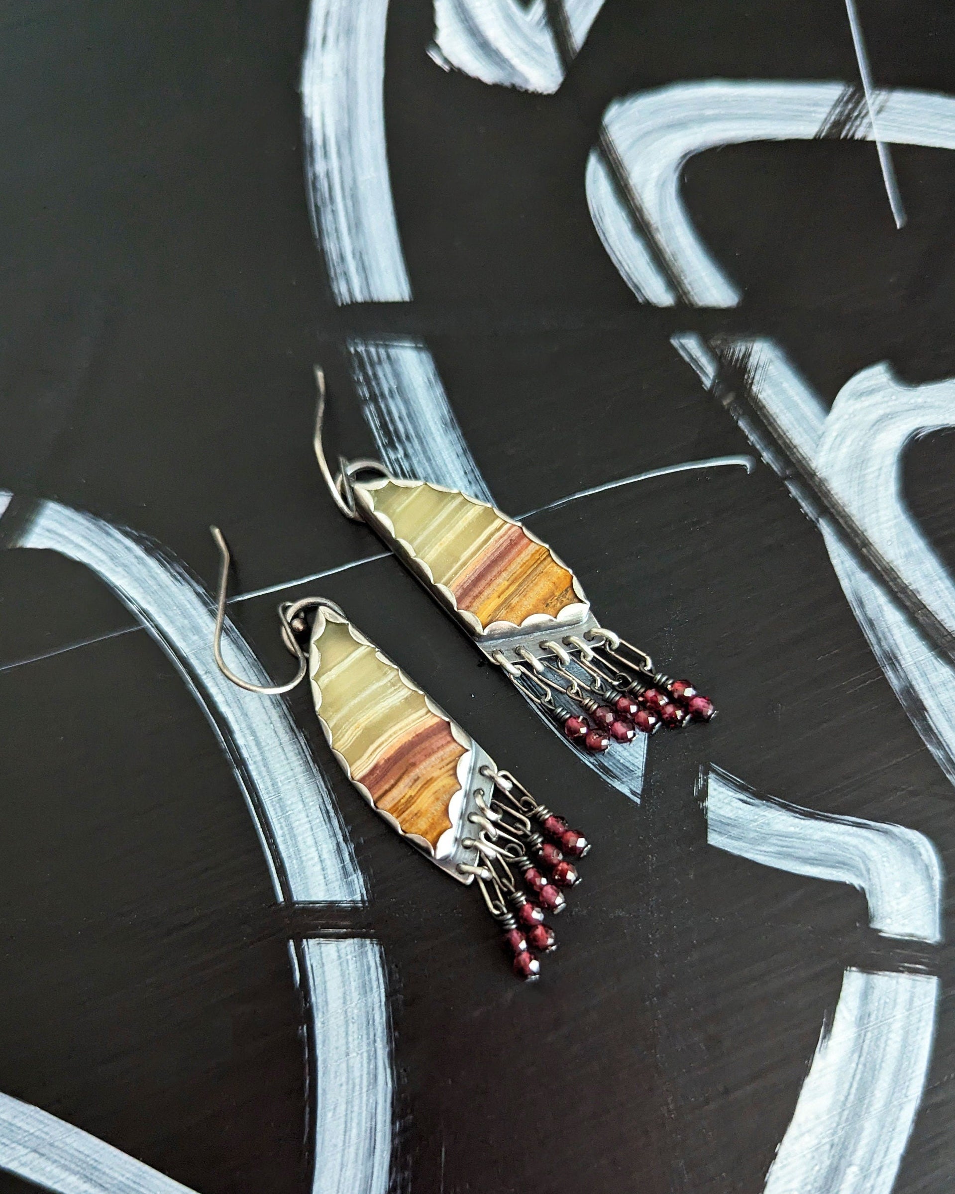 Asymmetrical green onyx drop earrings with garnet bead accents
