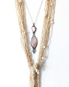 Druzy flower agate pendant with oxidized sterling silver and pearly thomsonite bail layered with a shell necklace

