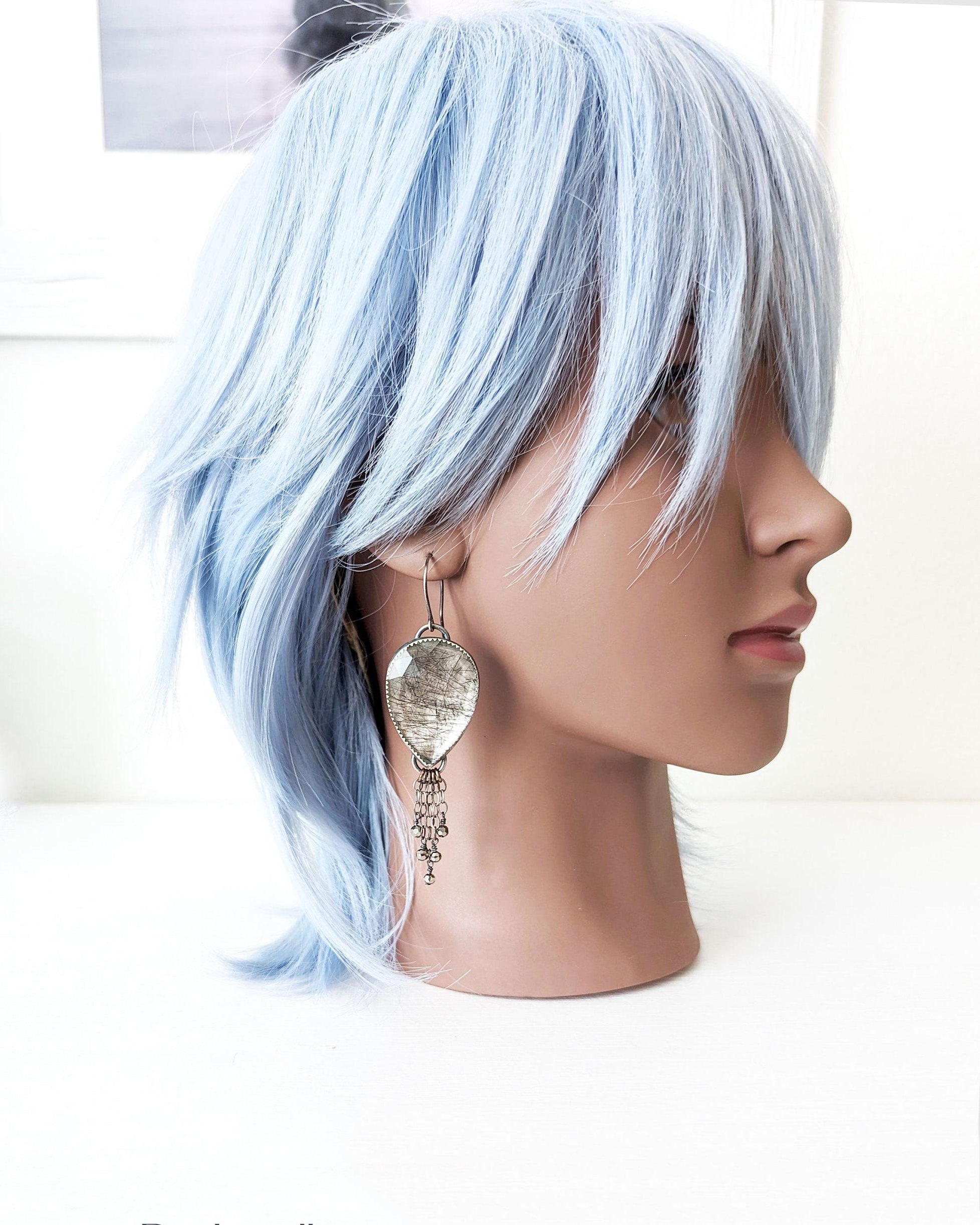 Large pear-shaped black rutile quartz earrings worn for size reference on mannequin

