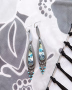 Earrings with multi colored stones on a decorative background