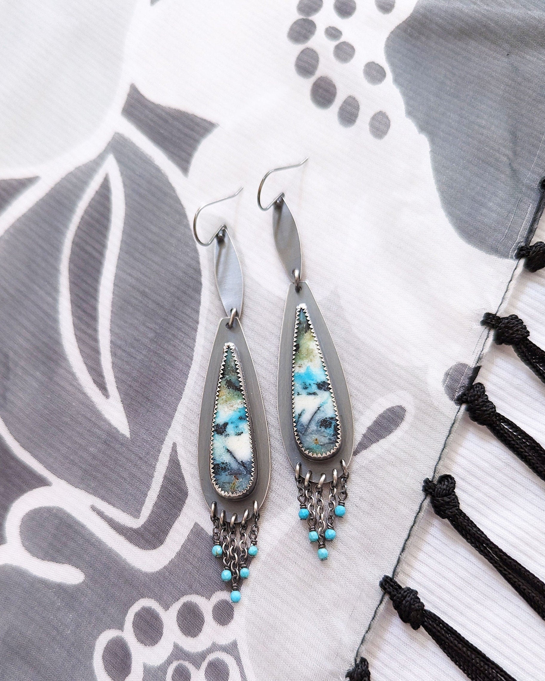 Earrings with multi colored stones on a decorative background