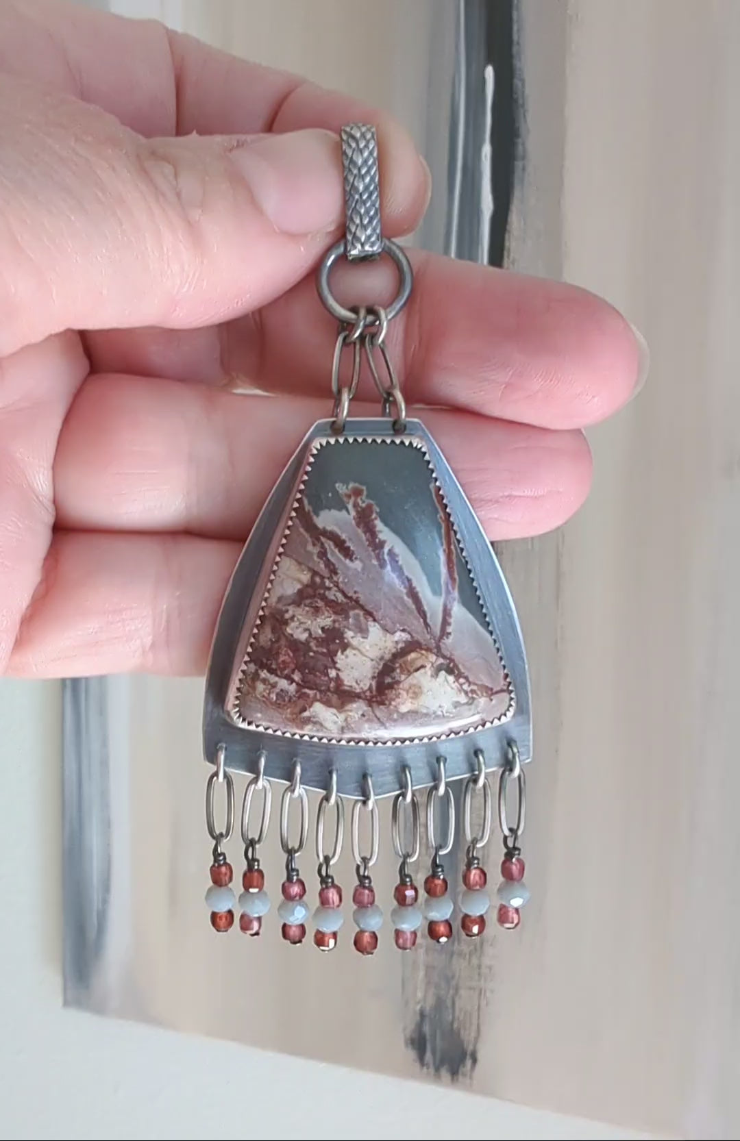 Video of statement necklace with shield shape and cascading fringe by Rebellenhaus