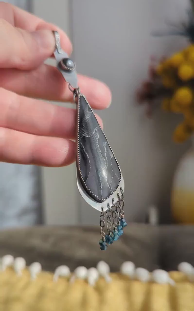 Video of artisan handmade gothic pendant with chain fringe and gemstone accents in natural light