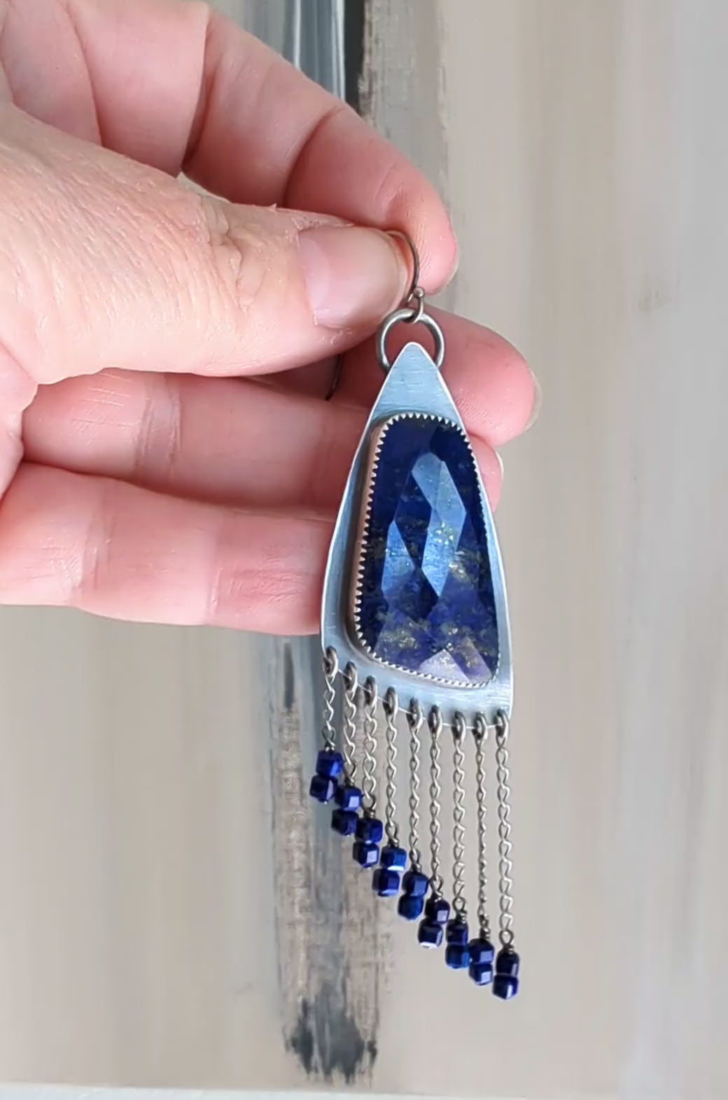 Video of boho luxury earrings with vivid blue gemstone and fringe