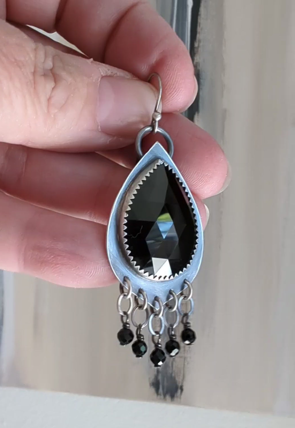 Video of bold artisan earrings with black spinel and silver movement