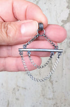 video showing scale and movement of a geometric oxidized silver pendant with industrial styling by Rebellenhaus