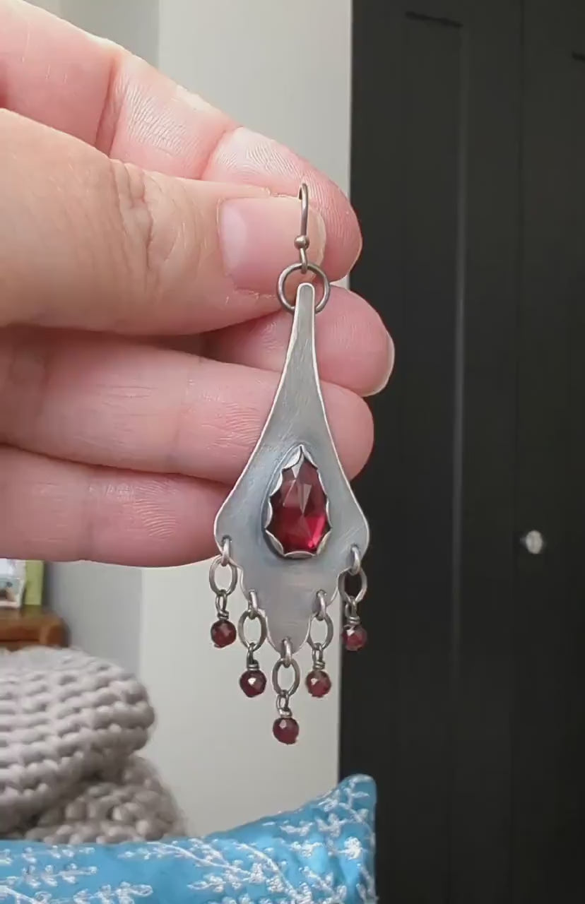 Video of artisan sterling silver earrings with scalloped frame and glowing garnet