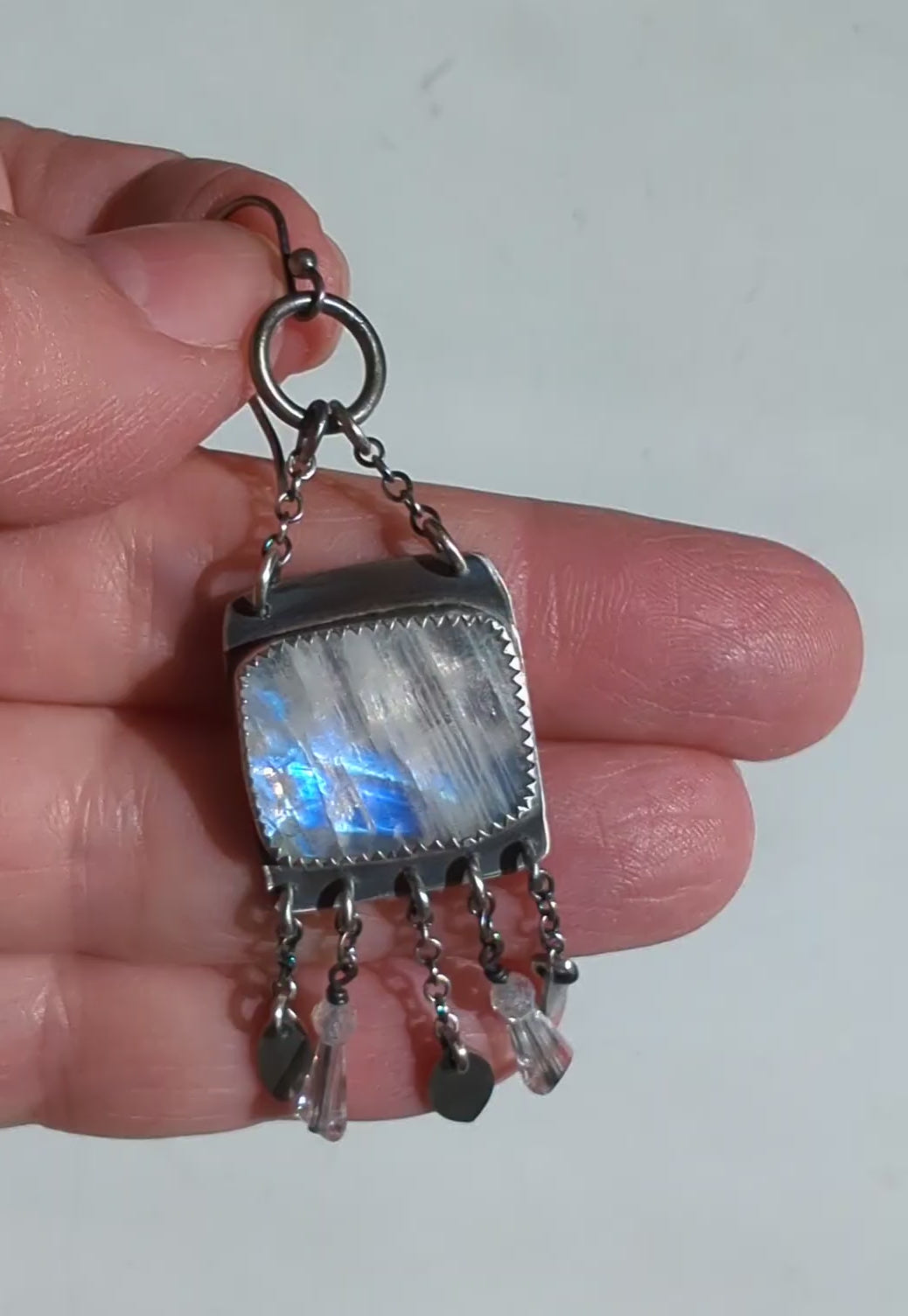 Video of unique silver earrings with square moonstone and dangling fringe