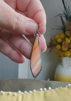 Video of artisan sterling silver earrings with bold orange seasonal tones